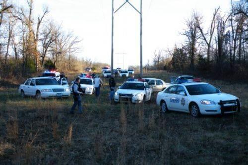 12-17-09 End of Felony Pursuit. At least 12 patrol cars are parks near the woods.