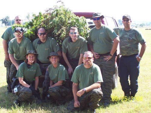 Nine reserve deputies pose for a photo next to a red truck