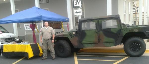 Sgt Chris Berry in front of booth and vehicle