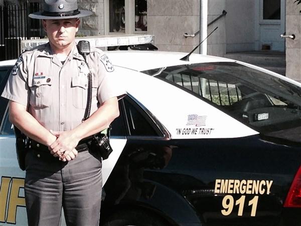 Officer standing by patrol car